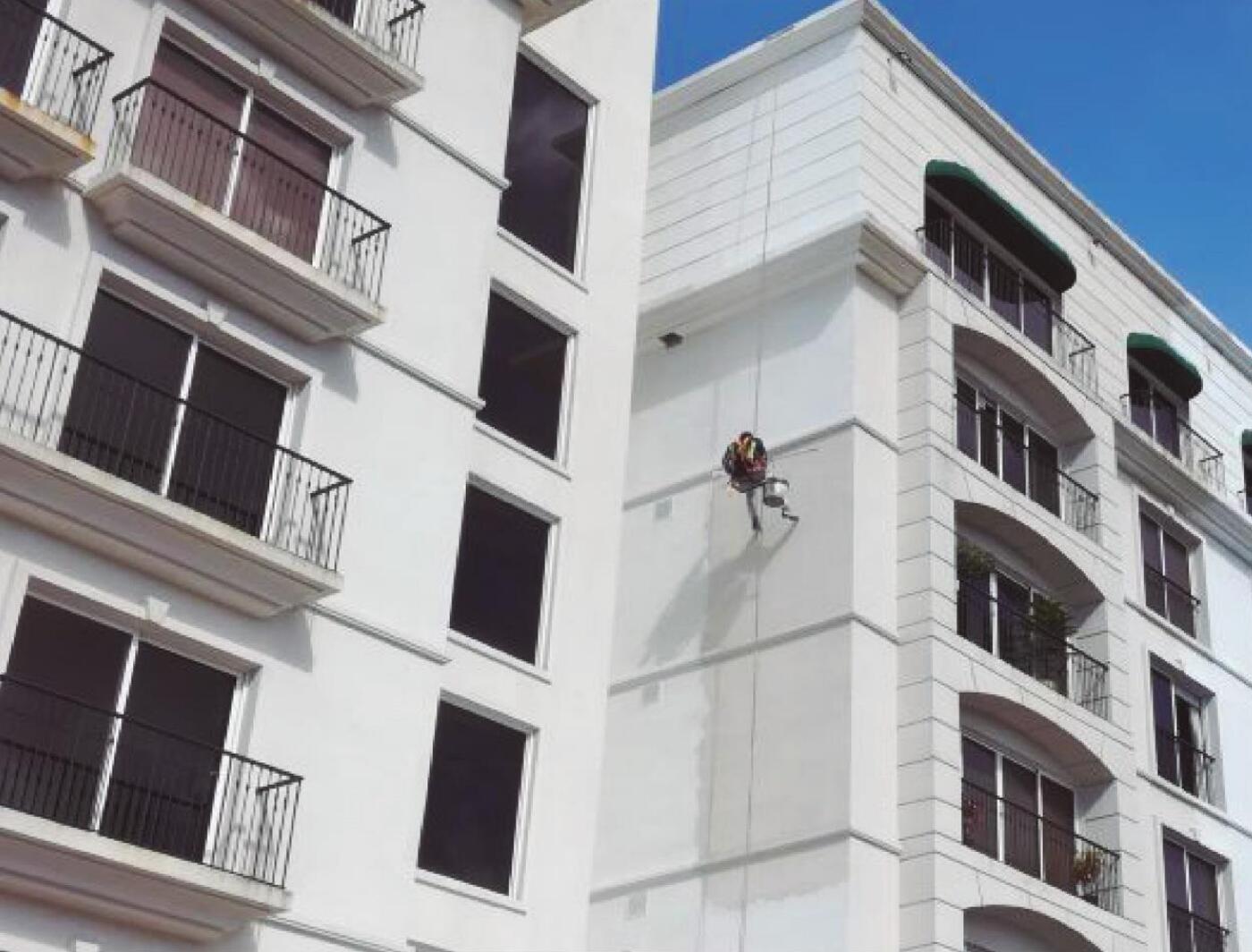 Trabajos de pintura en altura sobre la fachada de un edificio residencial